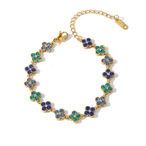 Detail view of a stainless steel gold bracelet with blue rhinestone flower charms