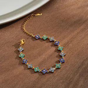 Close-up of a gold-plated flower bracelet with sparkling blue and teal rhinestones