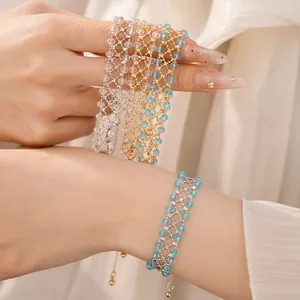 Primo piano di eleganti braccialetti in perline di vetro blu chiaro e trasparente sul polso