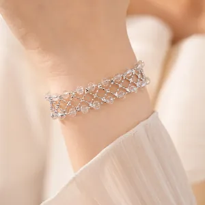 Vista dettagliata di un elegante bracciale traforato con perline di vetro al polso
