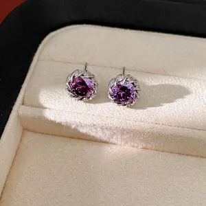 Elegantes pendientes de circonita púrpura redondos en un joyero de lujo premium.