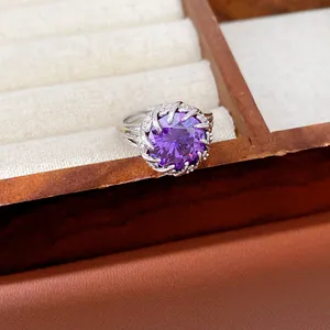 Primer plano de un anillo plateado con una gran piedra preciosa de circón púrpura.