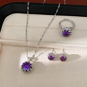 Elegante detalle de conjunto de joyas con circonitas púrpuras: collar, anillo y pendientes