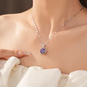 Vista detallada de un elegante collar con colgante de circón morado usado por una modelo