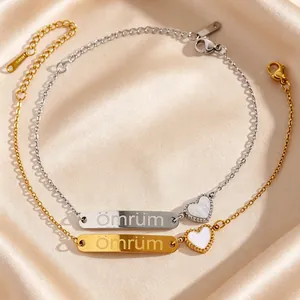 Vue détaillée de bracelets coeur en or et argent avec gravure Ömrüm sur du satin
