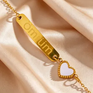 Détail macro d'un bracelet en acier doré avec gravure Ömrüm et breloque cœur