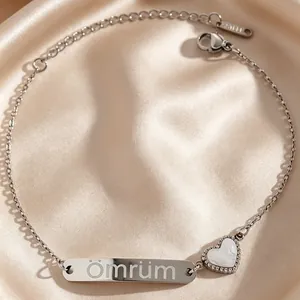 Gros plan d'un bracelet en acier inoxydable argenté avec gravure Ömrüm et détail de cœur