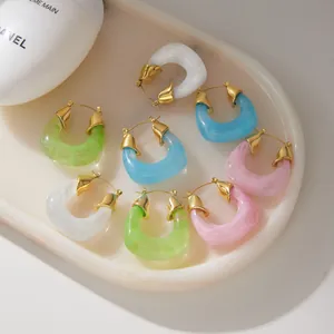 Close-up detail of colorful resin hoop earrings with elegant 18k gold plated metal accents