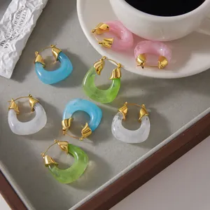 Detailed shot of multi-colored resin and gold-plated stainless steel hoop earrings