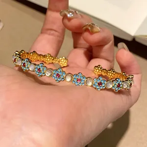 Exquisite gold-tone open bangle with blue oil-drop flowers and cat's eye stones