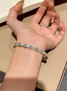 Detailed view of vintage-style enamel flower bracelet with cat eye stones and zircons.