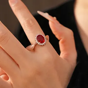Bague élégante avec zircon rouge ovale et halo pour collection de bijoux femme.