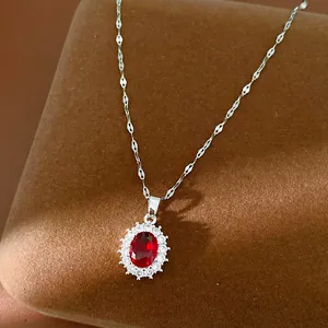 Vue détaillée du collier en argent avec pendentif ovale en pierre rouge entouré de zircons.