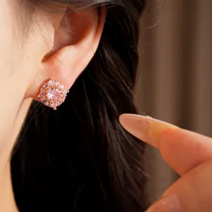 Primo piano di orecchini a lobo con zircone rosa e alone in finitura oro rosa