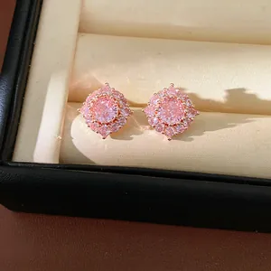 Primo piano di eleganti orecchini a lobo in zircone rosa a forma di fiore in un cofanetto.