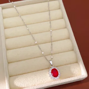 Vue détaillée d'un élégant collier avec pierre rouge ovale et halo de zircones brillants