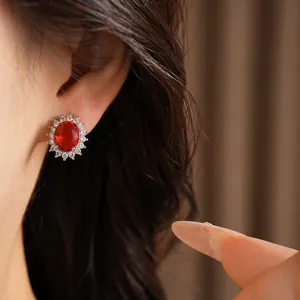 Vue détaillée de l'élégante boucle d'oreille en zircone rouge ovale sur l'oreille