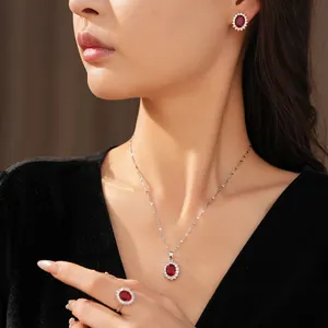 Parure élégante avec rubis rouges ovales, collier, boucles d'oreilles et bague sur modèle