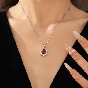 Gros plan d'un collier en argent élégant avec une pierre rouge ovale et un halo de zircons