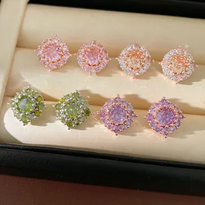 Primo piano di orecchini geometrici in argento con pietre di zircone colorate brillanti.