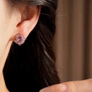 Dettaglio di un elegante orecchino a perno in oro rosa con cristalli di zircone viola