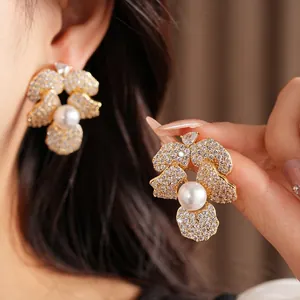 Elegant gold-plated floral stud earrings with cubic zirconia and a central white pearl