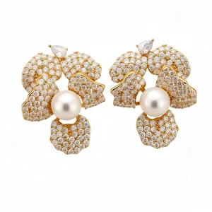 Elegant gold floral stud earrings featuring pavé-set zircons and a central lustrous pearl