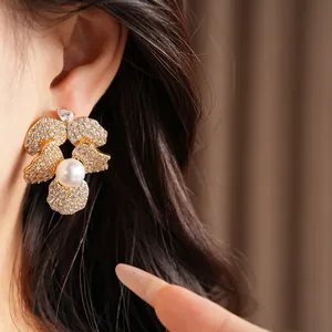Close-up detail of a sparkling zirconia flower earring with a central pearl