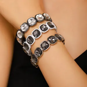 Close-up detail of stacked irregular acrylic bracelets with sparkling grey and clear crystals