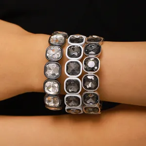 Close-up detail of three geometric square crystal elastic bracelets worn on a wrist
