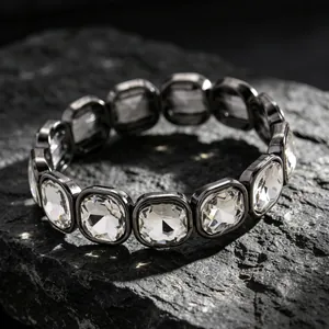 Close-up of a minimalist geometric stretch bracelet with square crystals and dark metal.