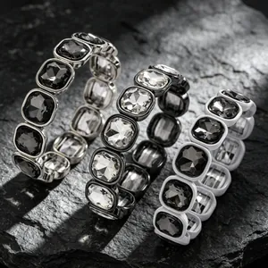 Detailed view of three geometric square faceted rhinestone elastic bracelets on dark stone