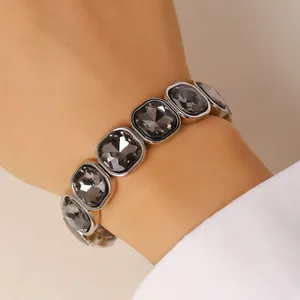 Macro view of an elegant silver elastic bracelet with square dark grey faceted crystals