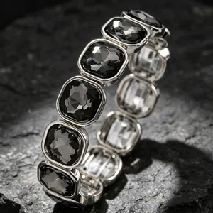 Detailed macro view of geometric square smoky grey gemstones on elastic silver tone bracelet