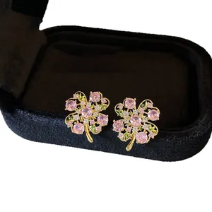 Sweet pink zircon flower stud earrings in gold plating displayed on velvet box