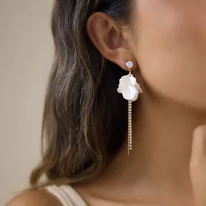 Close-up detail of a stainless steel tassel earring with acrylic petals on a model