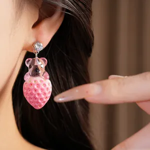 Vue détaillée de boucles d'oreilles ours et fraise en résine rose avec zircon brillant