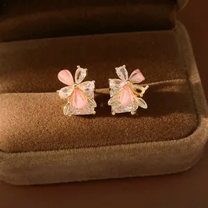 Primo piano di orecchini a fiore in zirconia con petali in resina rosa in box