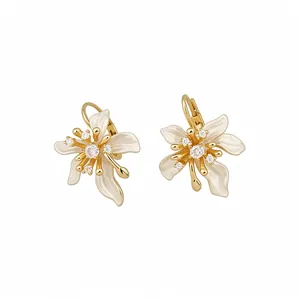 Elegant gold-plated flower earrings with white enamel petals and sparkling cubic zirconia