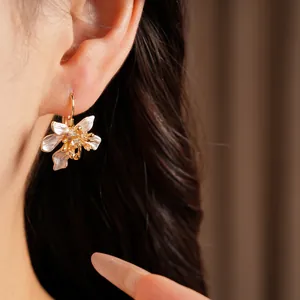 Detailed view of elegant white enamel flower hoop earrings with sparkling cubic zirconia
