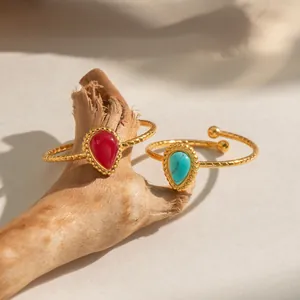 Close-up of vintage 18K gold plated rings with teardrop stones on a wooden branch