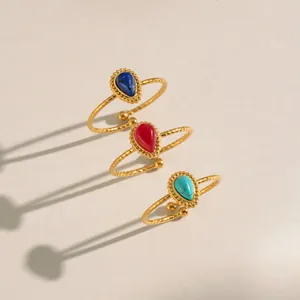 Detailed macro of vintage adjustable rings with colorful teardrop stones in 18K gold finish