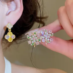 Primo piano di eleganti orecchini a fiore decorati con zirconi colorati e placcatura