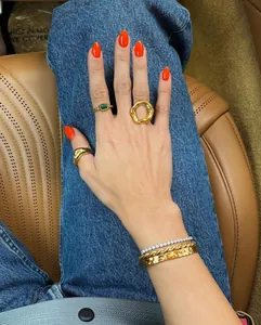 Detailed macro view of stacked 18K gold stainless steel geometric rings on female hand