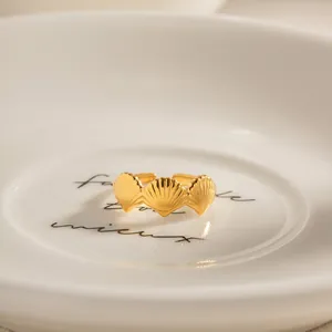 Detailed close-up of a gold stainless steel ring with elegant shell design