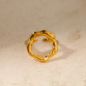 Close-up of a 18K gold-plated stainless steel ring with an organic, wavy geometric texture.