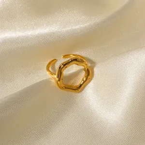 Close-up detail of a 18K gold plated stainless steel geometric wavy open ring on satin