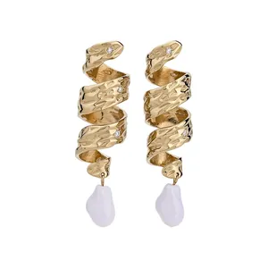 Boucles d'oreilles vintage en métal doré torsadé avec perles baroques blanches pendantes.