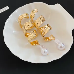 Vue détaillée de boucles d'oreilles vintage en métal doré torsadé avec perles baroques