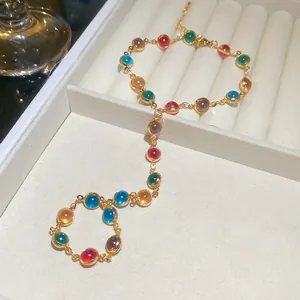 Exquisite gold-tone slave bracelet with vibrant colorful crystal cabochon stones detail